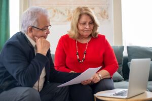 Senior couple reading through paperwork together at home
