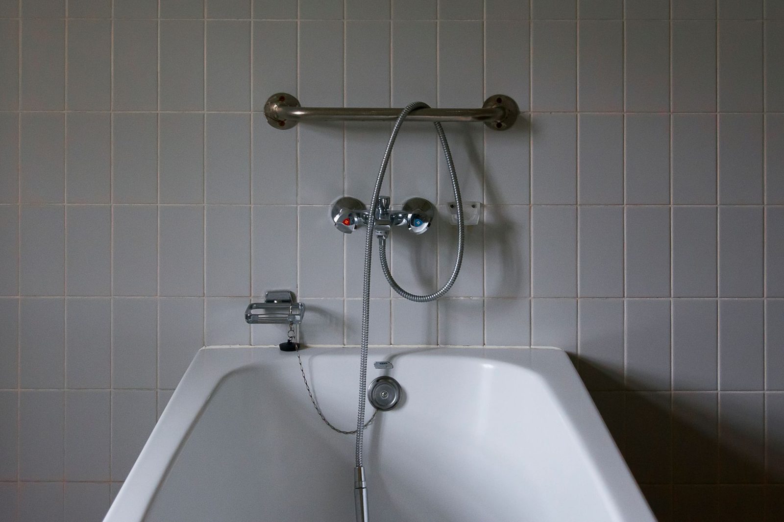 Bathroom with a grab bar fitted above the bathtub